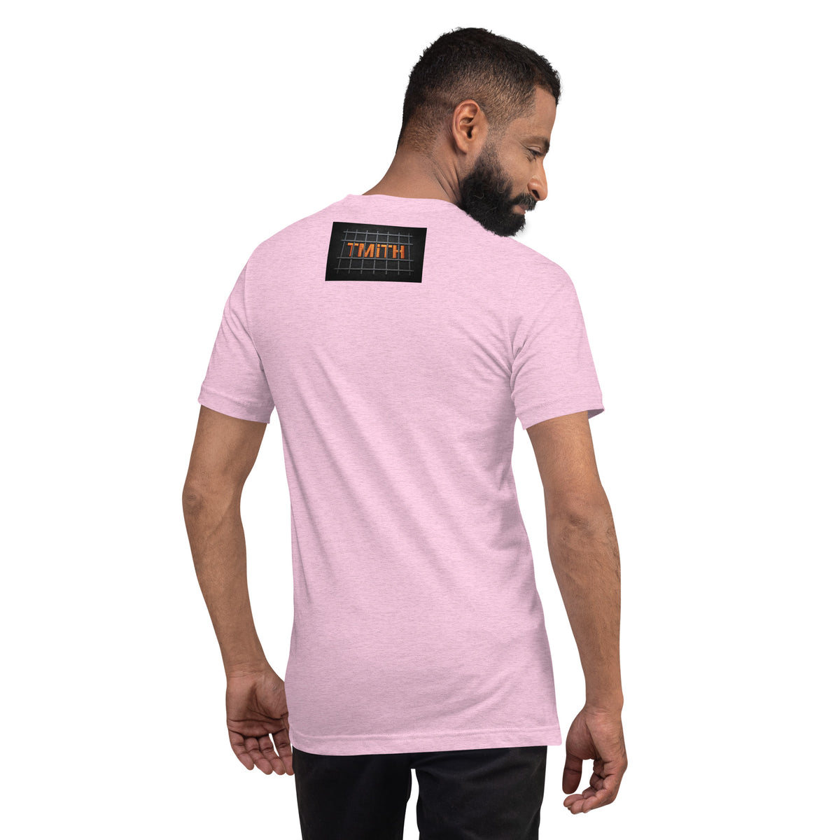 Model showing the back of a heather prism lilac TMiTH T-shirt with orange lettering behind gray prison bars. The Man in The Hat 907 artist merch expressing abuse-survivor solidarity.