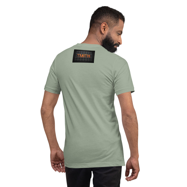 Model showing the back of a sage TMiTH T-shirt with orange lettering behind gray prison bars. The Man in The Hat 907 artist merch expressing mental health and raw expression.